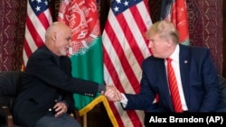 FILE: U.S. President Donald Trump shakes hands with Afghan President Ashraf Ghani at Bagram Air Field in November 2019. 