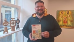 Томаш Блашчак на прэзэнтацыі трымае сваю кнігу «Беларусы ў Літоўскай Рэспубліцы (1918–1940)».