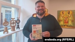 Томаш Блашчак на прэзэнтацыі трымае сваю кнігу «Беларусы ў Літоўскай Рэспубліцы (1918–1940)».