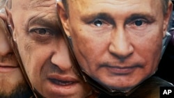 Masks depicting Russian President Vladimir Putin (right) and Wagner chief Yevgeny Prigozhin are displayed for sale at a souvenir shop in St. Petersburg in June 4.