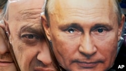 Maska me fytyrat e presidentit rus, Vladimir Putin (djathtas) dhe shefit të grupit mercenar rus, Yevgeny Prigozhin.
