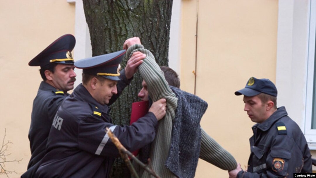 Міліцыянты заломваюць рукі Ігару Лапеху