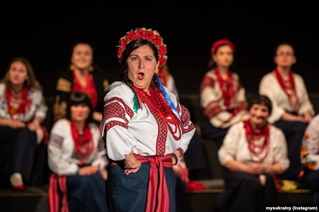 Виступ участиці хору під час вистави