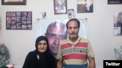 Zartosht Ahmadi Ragheb at his home near Tehran in August 2019. Behind him on the wall are photos of other imprisoned activists. File photo