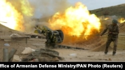 An ethnic Armenian soldier fires an artillery piece during fighting in Nagorno-Karabakh, October 5, 2020.