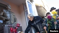 People leave flowers near the statue of Soviet dictator Josef Stalin in the town of Zaporizhzhya that was "beheaded" in 2011.