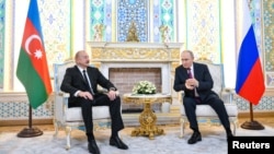 An image shows Russian President Vladimir Putin (right) meeting with Azerbaijani President Ilham Aliyev (left) on the sidelines of a summit in the Tajik capital, Dushanbe, on October 9.