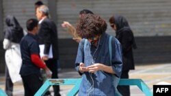 Muškarac koristi mobilni telefon dok stoji na trgu Valiasr u Teheranu, 19. aprila.