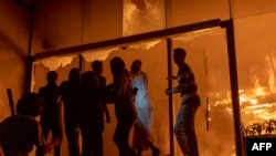 په ډاکه کې د ډېلې سټار ورځپاڼې په ودانۍ اور بل دی، په وره کې یې یوشمېر کسان ولاړ دي - د ډېسېمبر ۱۹مې انځور.