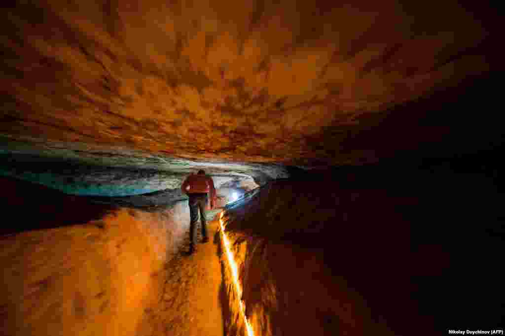 Bulgarian local guide Zhelyazko Velikov walks inside the Bacho Kiro Cave, near the city of Dryanovo.(AFP/Nikolay Doychinov)