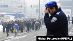 A policeman in Sarajevo looks on as retired Bosnian joint-army soldiers march in December for pension benefits.