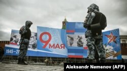 Rendőrök a győzelem napi állami ünnepség díszleteivel a moszkvai Vörös téren, április 28-án