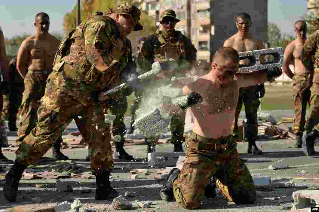 An Armenian serviceman breaks blocks on another serviceman using a sledgehammer during celebrations marking the 23rd anniversary of the formation of the reconnaissance troops of the country's armed forces in Yerevan. (AFP/Karen Minasian)