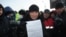 Протестующий показывает лист бумаги с требованиями. Актау, 19 декабря 2011 года. 