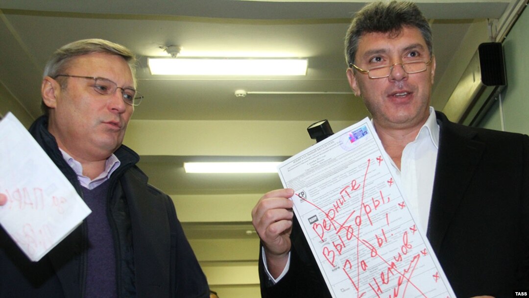 Opposition leaders Mikhail Kasyanov (left) and Boris Nemtsov show their defaced ballots during parliamentary elections at a polling station in Moscow in December 2011.