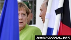 German Chancellor Angela Merkel and Russian President Vladimir Putin chat outside Meseberg Castle on August 18.