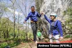 Nedu helps Cosmin Candoi to balance on a slackline at a Climb Again camp.