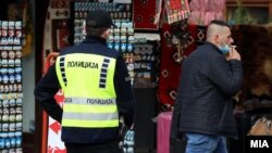 Полиција и граѓанин без заштитна маска на лицето во Скопје