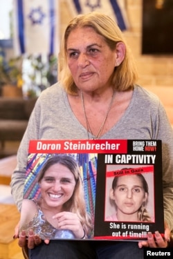 În imagine, mama lui Doron Steinbercher (31 de ani), cu cetățenie română și israeliană, ține o fotografie cu fiica ei, în timpul unui interviu din martie 2024.