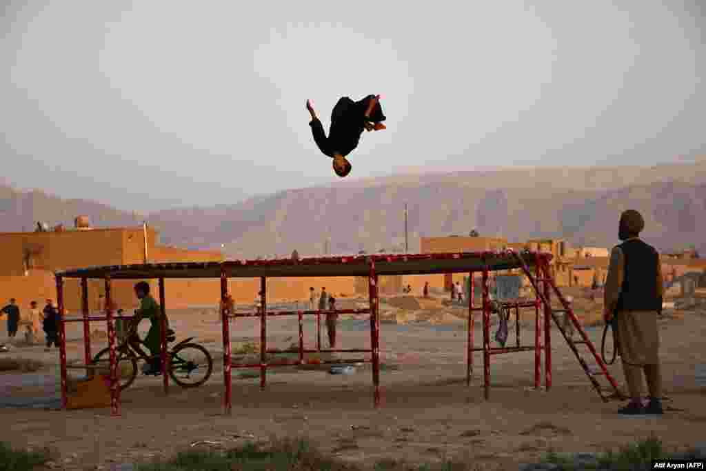 Një djalë duke luajtur në një trampolinë në periferi të Mazar-e Sharifit, Afganistan.