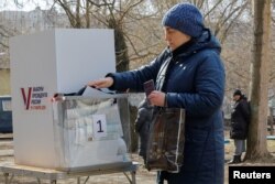 O femeie votează anticipat la o secție de votare mobilă în Donețk, teritoriu ucrainean controlat de Rusia. 10 martie 2024.