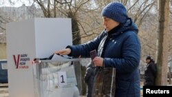 O femeie votează anticipat la o secție de votare mobilă în Donețk, teritoriu ucrainean controlat de Rusia. 10 martie 2024.