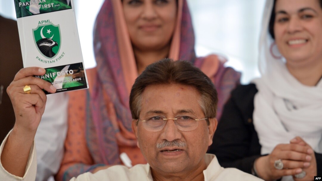 Former President Pervez Musharraf holds a copy of his party manifesto at his residence in Islamabad on April 15.