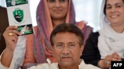 Former Pakistani President Pervez Musharraf holds a copy of his party manifesto for the forthcoming general election at his residence in Islamabad on April 15.