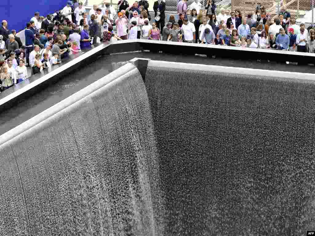 Relatives of 9/11 attack victims gather next to the memorial pool during ceremonies marking the 10th anniversary of the World Trade Center attacks in New York.