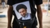 یک زائر محرم در مرز چذابه عکسی از مجتبی خامنه‌ای را با خود حمل می‌کند