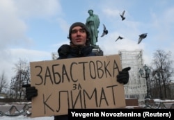 Climate activist Arshak Makichyan holds a cardboard sign reading "Strike for climate" during a single-person demonstration in central Moscow in February 2020.