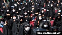 Iran Virus Outbreak Ashoura -- People wearing protective face masks to help prevent spread of the coronavirus mourn during an annual ceremony commemorating Ashoura, the anniversary of the 7th century death of Imam Hussein, a grandson of Prophet Muhammad, 