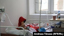 O pacientă stă întinsă pe un pat de spital. Institutul de Pneumoftiziologie Marius Nasta, București.