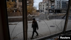 A photographer walks past buildings damaged by a Russian military strike in the town of Pokrovsk, Ukriane, on November 4.