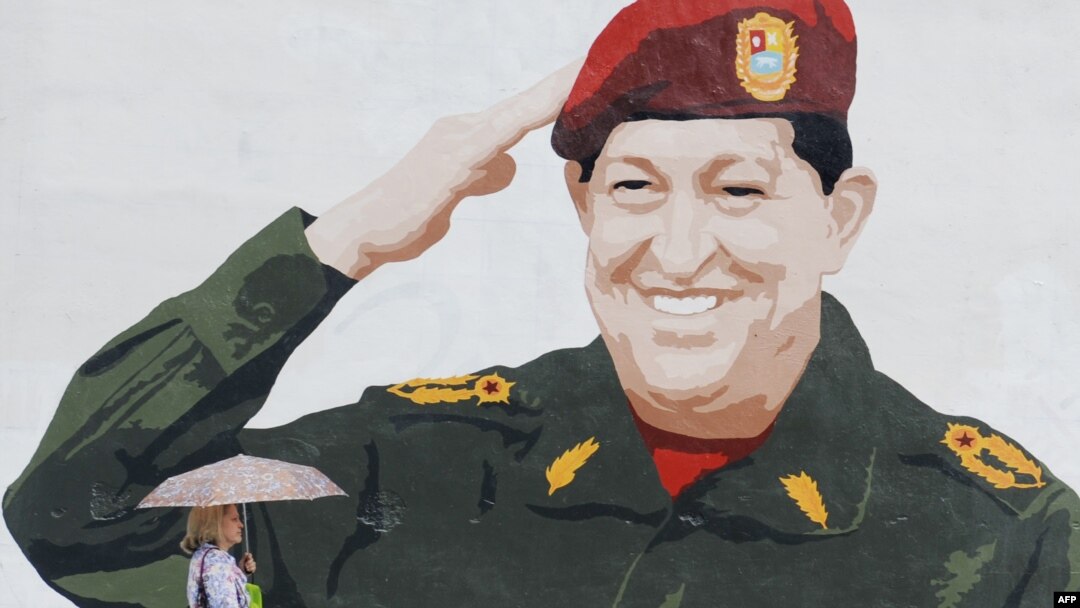 Venezuela -- A woman walks by a graffiti depicting President Hugo Chavez in Caracas, 24Apr2012