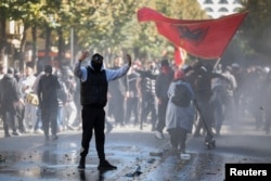 Një protestues duke iu drejtuar policëve gjatë protestes antiqeveritare në Tiranë, më 16 tetor.