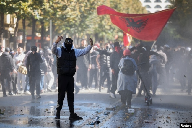 Një protestues duke iu drejtuar policëve gjatë protestes antiqeveritare në Tiranë, më 16 tetor.