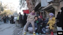 Children sit with their baggage during the evacuation of Aleppo in December 2016. 