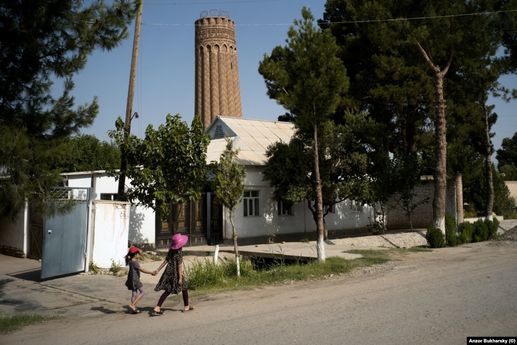 Two local girls walk near a 900-year-old minaret in the southern town of Minor, near the border with Afghanistan.