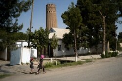 Iki ýerli gyz ýurduň Owganystan bilen serhet ýakasynda ýerleşýän Minor şäheriniň günortasyndaky 900 ýyllyk minaranyň golaýynda ýöräp barýarlar.