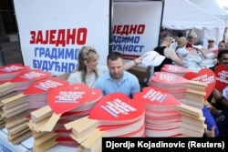 Štandovi sa stranačkim rekvizitima koji se dele na mitingu Srpske napredne stranke, 27. jun 2026.