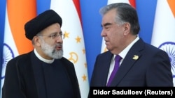 Tajik President Emomali Rahmon (right) and Iranian President Ebrahim Raisi speak while posing for a picture during the Shanghai Cooperation Organization summit in Dushanbe in 2021.