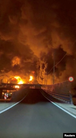 Пламъци и дим се издигат над нефтохранилището близо до Техеран, което беше атакувано в събота вечерта. 8 март 2026 г.