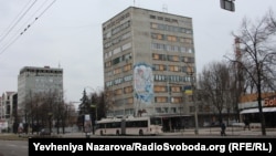 Будинок із забитими фанерою (вибитими внаслідок російського обстрілу) вікнами. На цетральному проспекті Запоріжжя, лютий 2026 року 