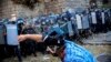 Мъж хвърля слама срещу полицията, която е направила кордон около Партийния дом, където сега заседава парламентът, 2 септември 2020 г.