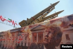 Un banner cu o fotografie a președintelui SUA, Donald Trump, alături de un sistem de rachete iranian, în Piața Azadi („Libertatea”) din Teheran