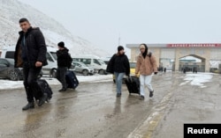People enter Turkey after crossing from Iran at the Kapikoy Border Gate in the eastern Van Province on January 15.