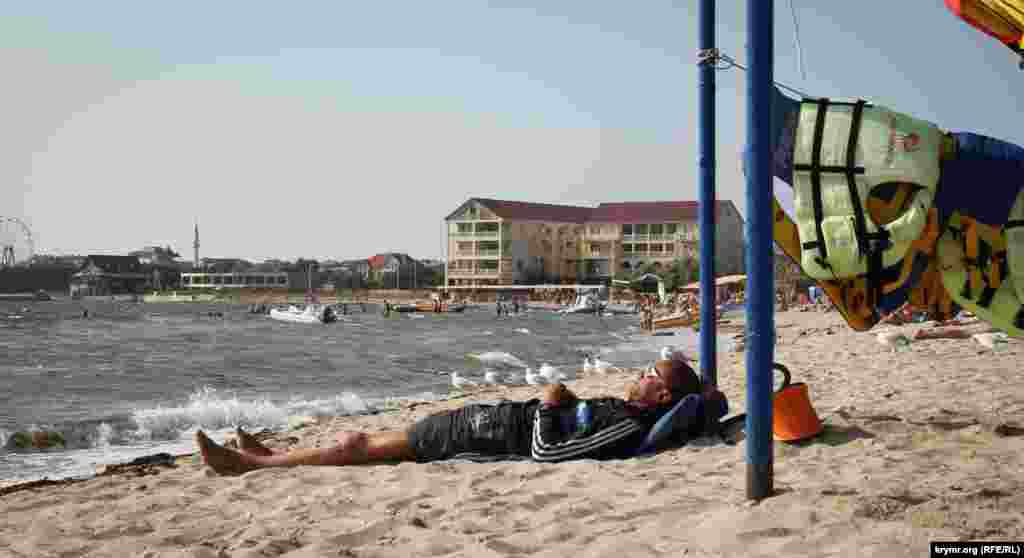 На пляжі є водні розваги. Працівники дрімають в очікуванні поодиноких клієнтів. 16 година, 15 серпня.