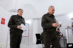 Șeful statului major al armatei ruse, Valeri Gherasimov (stânga), votând împreună cu ministrul Apărării de atunci, Serghei Șoigu, la alegerile prezidențiale rusești, la 15 martie 2024.