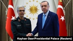 Turkish President Recep Tayyip Erdogan greets the chief of staff of Iran’s armed forces, Mohammad Baqeri, in Ankara on August 16. 